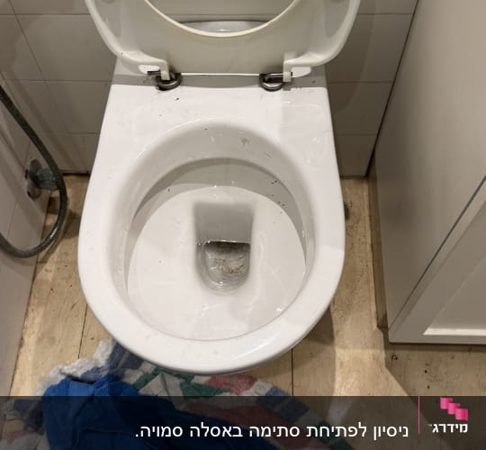 אסלה פתוחה עם מגבות על הרצפה